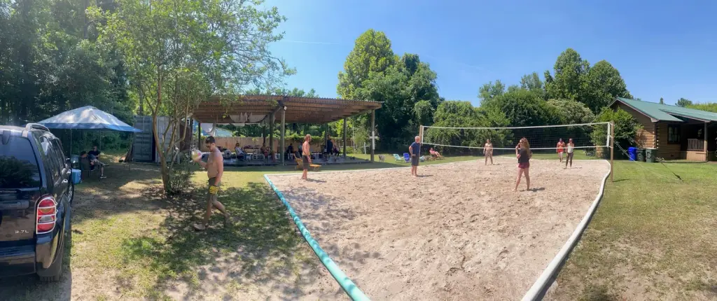 The sand volleyball court, covered pavilion and cabin at Still Worthy