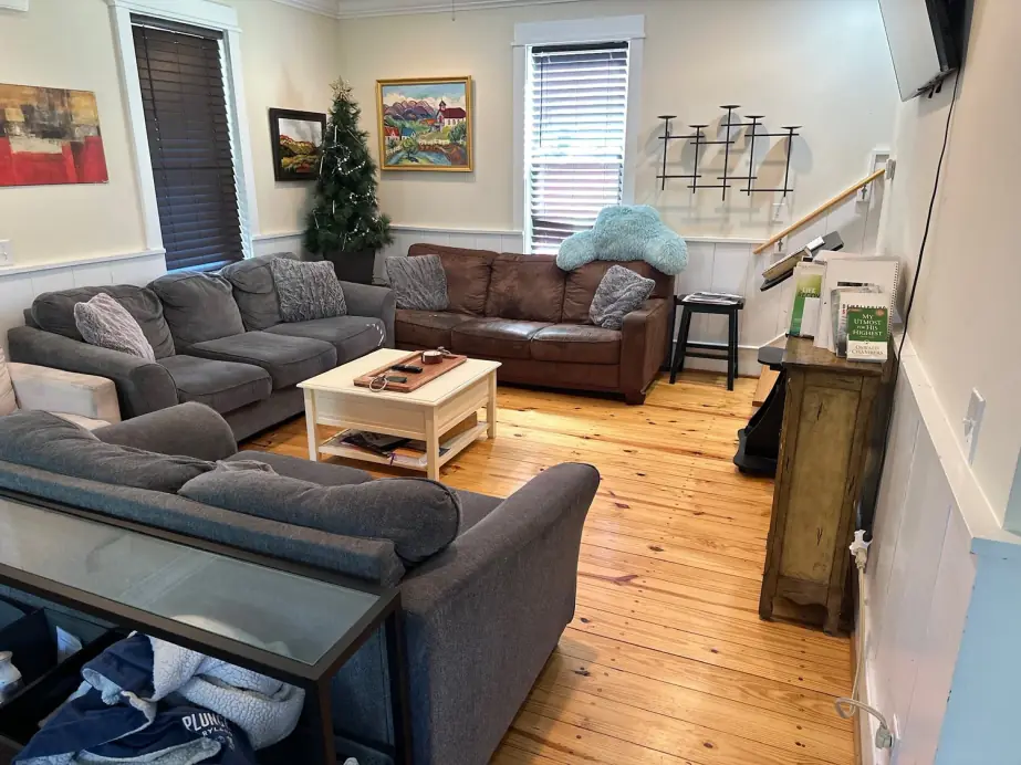 Sectional sofas and pine floors in the living room of a Still Worthy residence