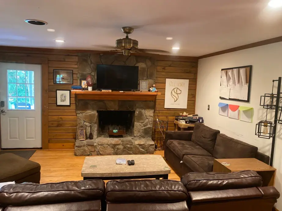 Living room at a Still Worthy residence with a stone fireplace and leather sofas